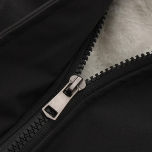 Close-up of black windbreaker zipper with warm white fleece lining and metal puller