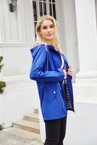 Detail of bright blue rain jacket with silver zipper and black and white striped lining