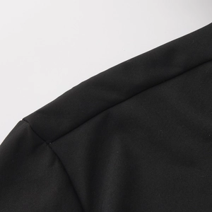 Close-up of the waterproof woven fabric and neat seam stitching on the black hooded jacket