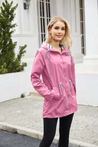 Detail of pink waterproof hooded raincoat featuring a stylish black and white striped lining