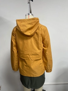 Back view of ginger yellow hooded windbreaker featuring a large flap pocket and elastic cuffs