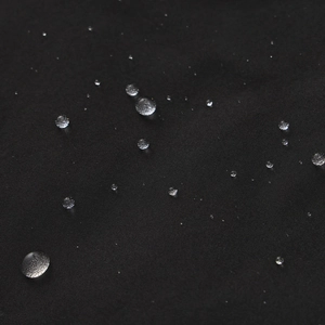 Detailed macro shot of the black water-resistant fabric with hydrophobic water droplets