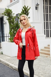 Detail of red hooded raincoat featuring striped lining and adjustable waist drawstring