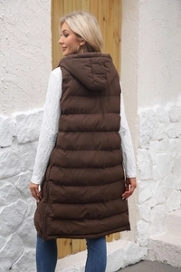 Detail of a long quilted hooded vest in dark coffee featuring side zipper vents and texture