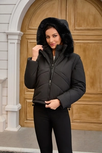 Detailed close-up of a women's black hooded jacket with faux fur trim and V-shaped quilting
