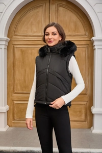 Detail of hooded black quilted puffer vest featuring premium faux fur trim and sleek metal zipper