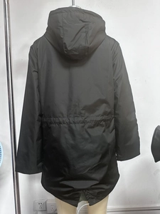 Rear view of black waterproof long trench coat with drawstring waist and hooded design