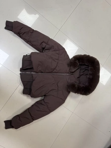 Dettaglio del cappotto marrone con collo in pelliccia e polsini in maglia a coste