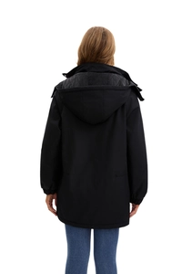 Rear view of women's black hooded parka featuring grey diamond quilted lining details