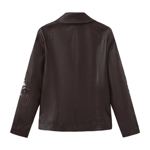 Close-up of floral embroidery on the back of a dark brown faux leather jacket for women