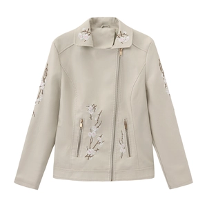 Close-up of floral embroidery on cream faux leather motorcycle jacket with metal zippers