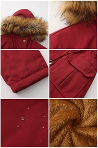 Détail de parka rouge avec tissu imperméable, capuche en fourrure et doublure polaire brune