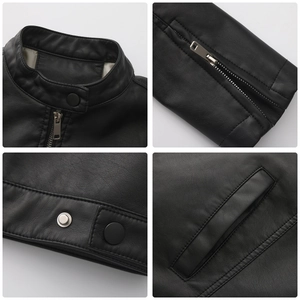 Detail view of black moto jacket featuring stand collar, silver zippers, and metal snap buttons