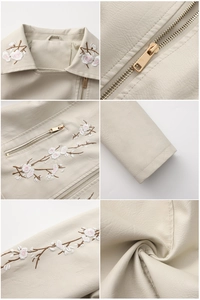 Détails de broderie florale sur une veste en similicuir crème avec zips métalliques dorés