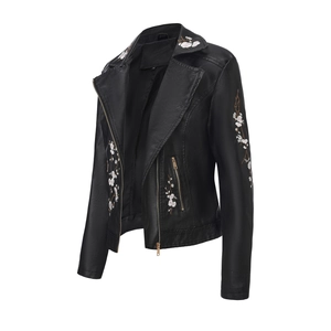 Gros plan sur la broderie florale rose et la texture de la veste de moto noire