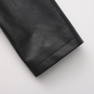 Macro detail of high-quality leather grain and neat stitching on black jacket cuffs