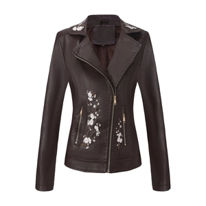 Vue détaillée de la broderie florale blanche sur une veste de motard en cuir PU