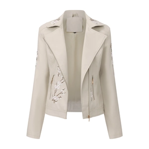Détail de la broderie fleur de cerisier et poches zippées sur veste en similicuir crème