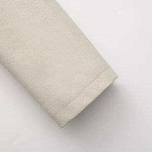 Detailed close-up of cream faux leather sleeve with premium lychee texture and stitching