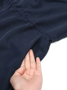 Close-up of deep blue jumpsuit side pockets with high-quality seamless stitching