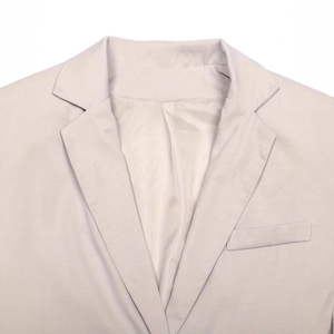 Detailed view of women's vest lapel collar and chest pocket in ivory white
