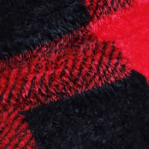 Close-up of fluffy red and black plaid faux fur texture on a warm winter cardigan