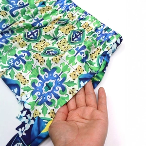 Detail view of colorful printed beach shorts with elastic waist and side pockets