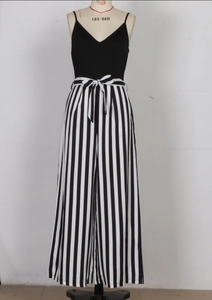 Detail of high waisted striped wide leg jumpsuit with black V-neck camisole top and waist tie