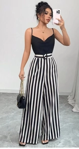 Detail of high waisted striped wide leg pants with a black V-neck camisole and belt