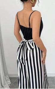 Rear view of wide-leg jumpsuit with black camisole top and striped pants with a bow tie
