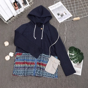 Detail view of quilted navy jacket with ethnic pattern patchwork and zipper closure