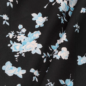 Vue macro détaillée du tissu noir tissé avec d'élégants motifs floraux bleu clair