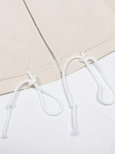 Detail of cream casual jacket hem featuring silver zipper and adjustable cotton drawstring