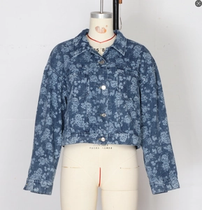 Close-up of floral print denim jacket featuring silver metal buttons and flap pockets