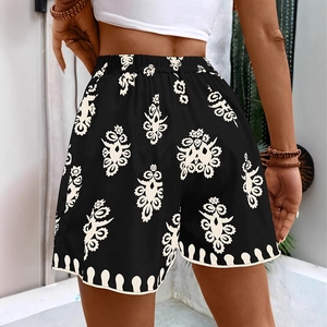 Detail view of high-waist printed shorts featuring bohemian mandala patterns and curved hem