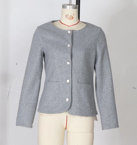 Detail der grauen Tweed-Jacke mit Rundhalsausschnitt und Metallknöpfen auf Wollmischung