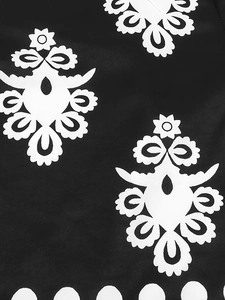Close-up of bohemian style black and white floral print fabric with wavy scalloped hem