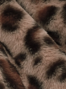 Macro shot of soft faux fur leopard print texture on a warm winter plush jacket