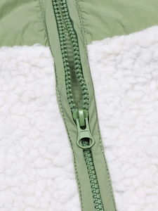 Détail du nylon vert et de la polaire blanche avec fermeture éclair à anneau assortie