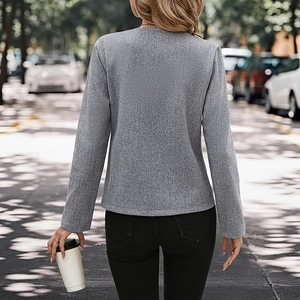 Straßenansicht einer Frau in schicker grauer Tweed-Jacke und schwarzer Hose im urbanen Stil