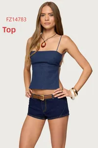 Détail d'un caraco en jean bleu foncé et d'un short assorti avec ceinture en cuir