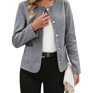 Detail eines grauen Tweed-Blazers mit weißen Rundknöpfen und eleganten Vordertaschen