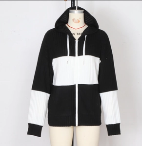 Dettaglio del cardigan con cappuccio che mostra il design bicolore bianco e nero a coste