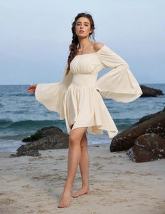 Détail de la mini-robe crème à épaules dénudées avec des manches cloches évasées