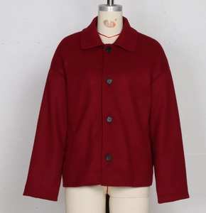 Detail view of burgundy wool coat with single-breasted black buttons and flat collar