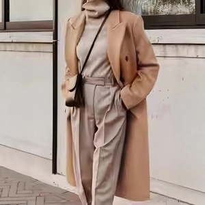 Detail of camel wool coat with notched lapel and double-breasted buttons in street style