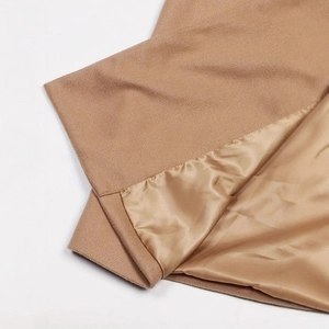 Detailed close-up of camel wool texture and smooth satin lining on a double-breasted coat