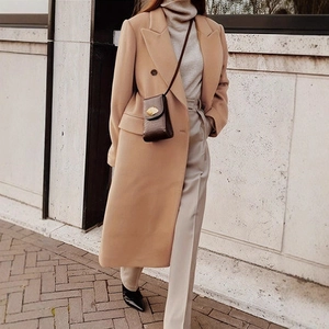 Detail of classic camel double-breasted wool coat with notch lapels and elegant slim fit