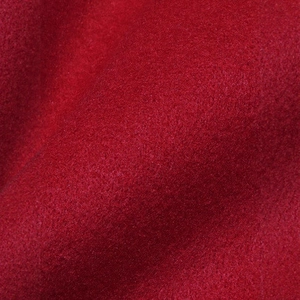 Macro shot of high-quality red wool fabric texture with soft fiber detail and plush surface