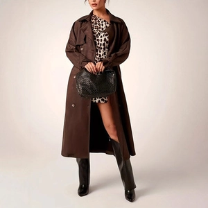Detail of a brown double-breasted coat paired with a leopard skirt and woven handbag
